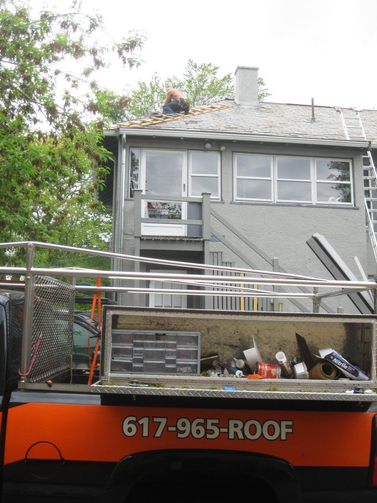 Residential roof installation with repairs on existing roof areas.