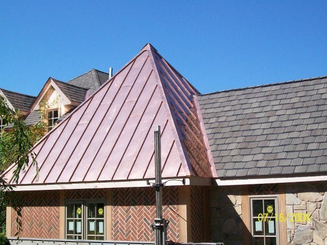 Copper roof installation on a residential property providing durability and elegance.