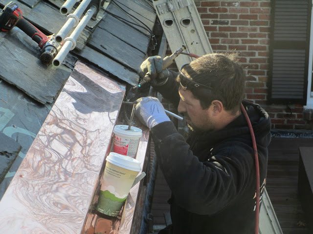Restored wood gutters with copper lining to prevent water damage and extend lifespan.